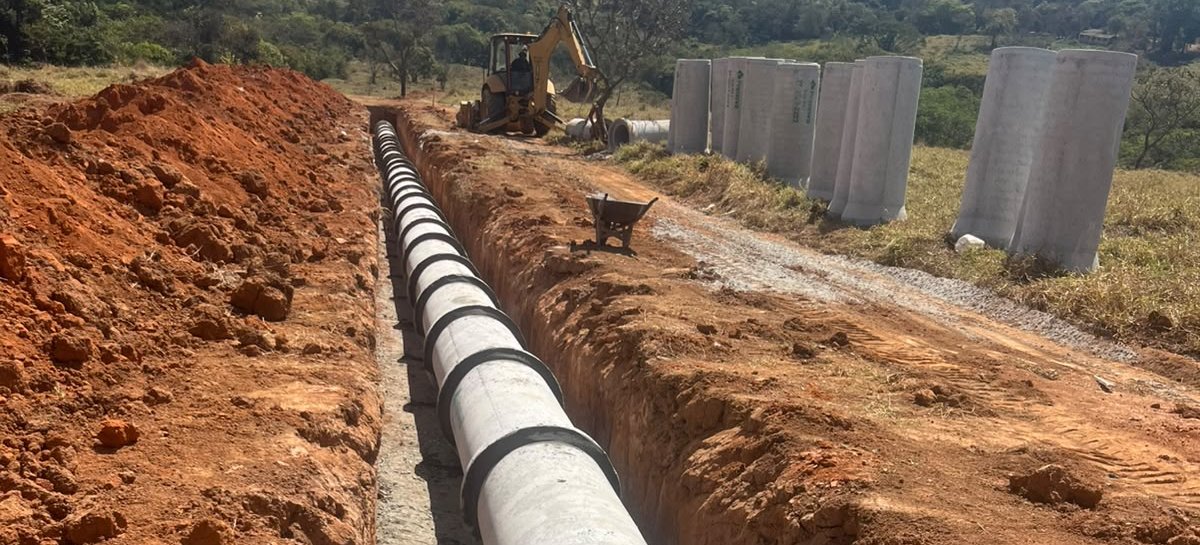 Retroescavadeira e tubos em obra de drenagem pluvial da Gidê