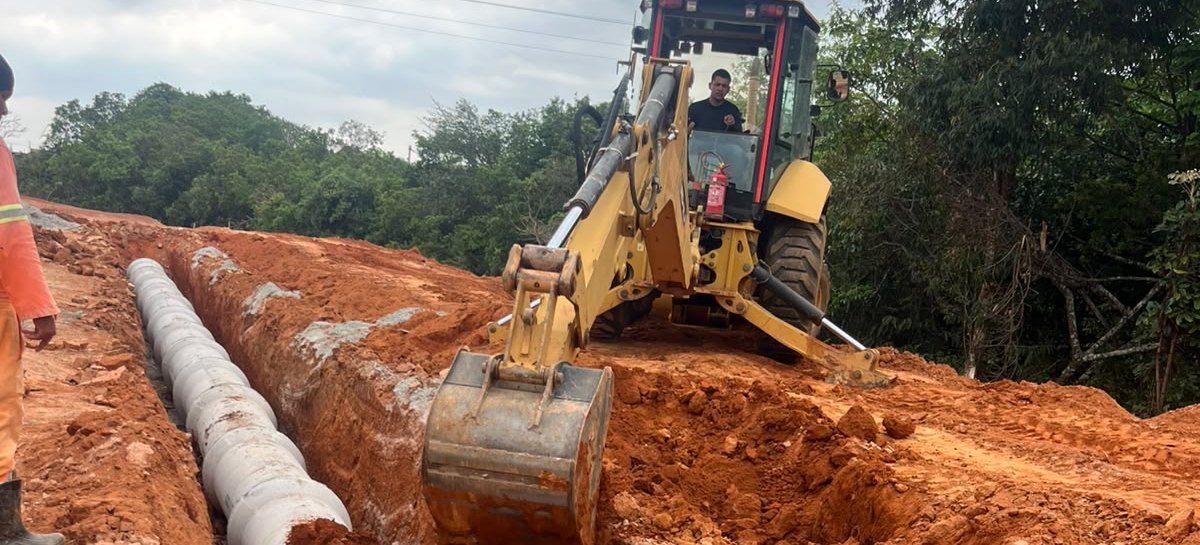 Retroescavadeira e tubos em obra de drenagem da Gidê