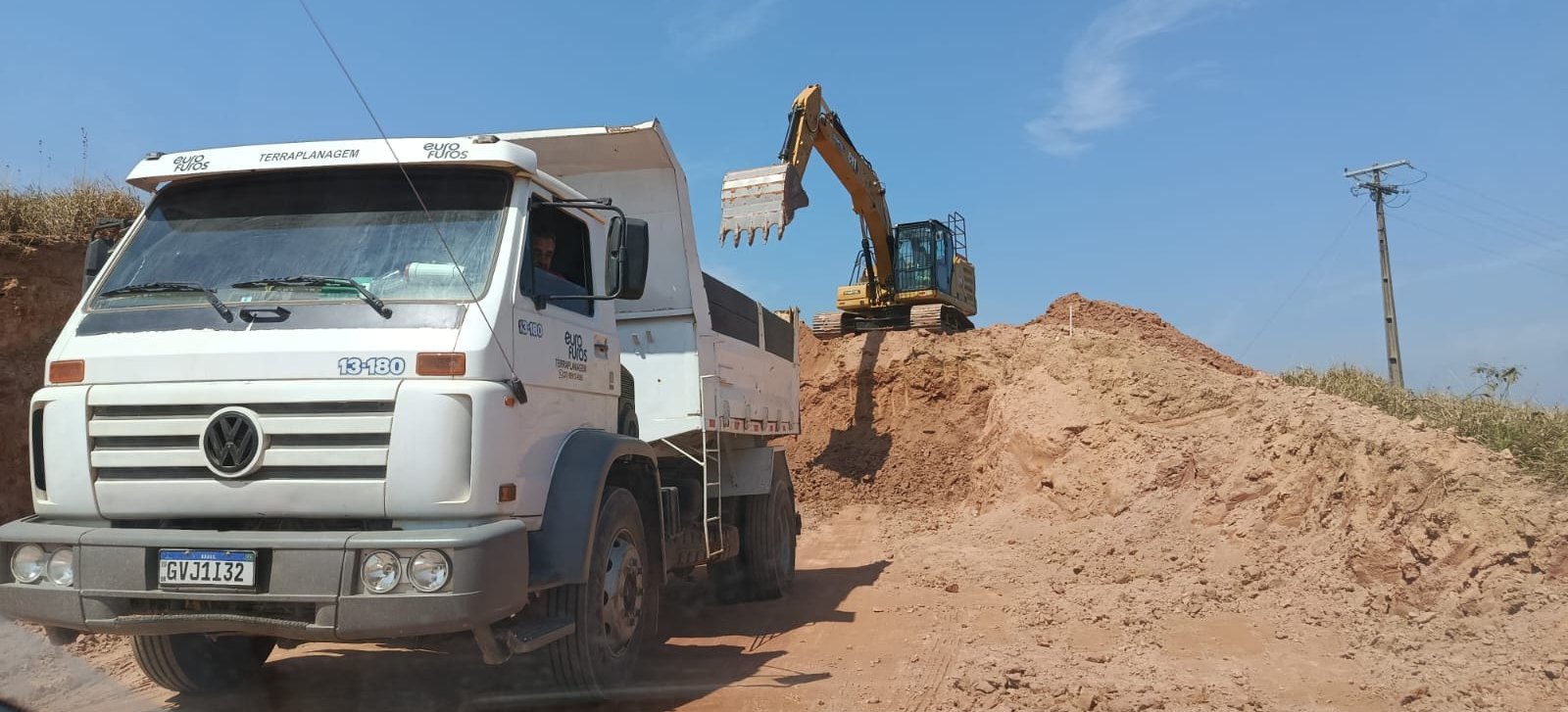 Caminhão e escavadeira em obra de terraplenagem da Gidê